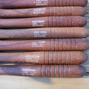 May include: A set of eight wood-handled chisels with silver blades. Each chisel has a white label with the text "CRAFTSMAN" and "HIGH SPEED STEEL".