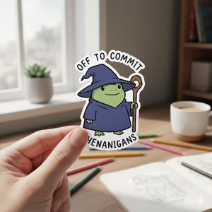 May include: A sticker featuring a cartoon frog wearing a wizard hat and robe, holding a staff. The text on the sticker reads "Off to Commit Henanigans."