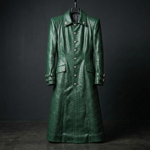 May include: A long, emerald green coat with a textured, snakeskin-like pattern. The coat features a button-up front, two front pockets, and decorative details on the cuffs. The coat is hanging on a black hanger against a dark background.