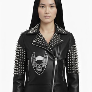 May include: Black leather jacket with silver metal cone studs on the shoulders and collar. Features a skull and wings patch on the chest. The jacket has a zipper closure and a classic biker style.
