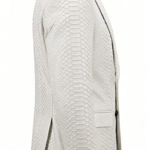 May include: A white blazer with a textured, snakeskin-like pattern. The jacket features a notched lapel, a single-breasted closure with four black buttons on the cuff, and a single pocket. The overall design is sleek and modern.