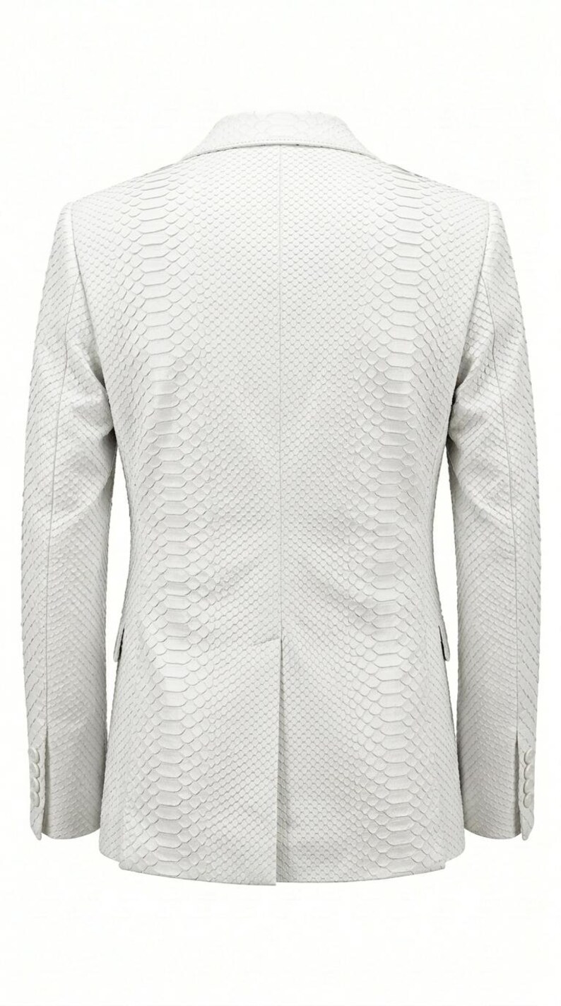 May include: A white blazer with a snakeskin pattern. The back view of the jacket shows a tailored fit with a two-button closure and notched lapels. The sleeves have buttoned cuffs. The blazer is made of a textured material.