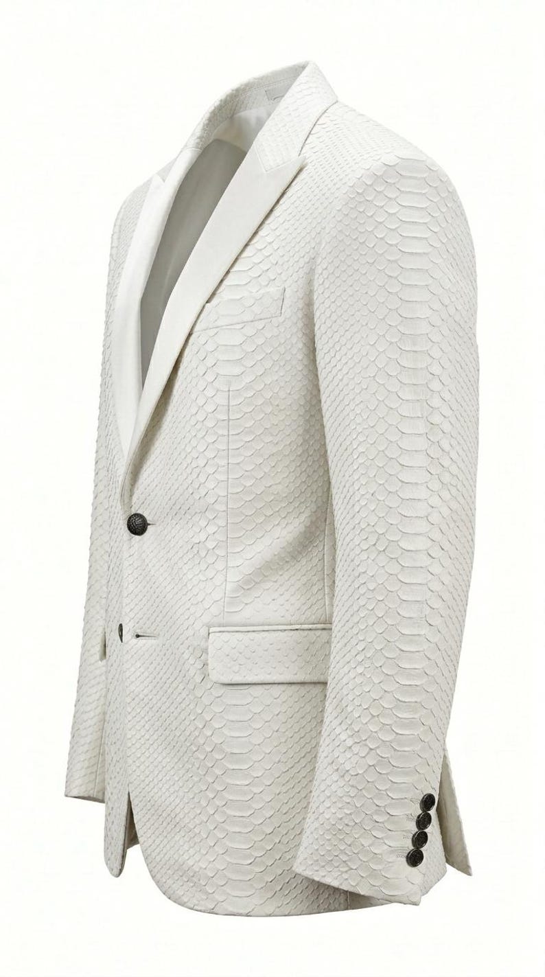 May include: A white blazer with a textured, scale-like pattern. The jacket features a notched lapel, a single-button closure, and a pocket on the front. The sleeves have four buttons at the cuff. The blazer is a formal garment.
