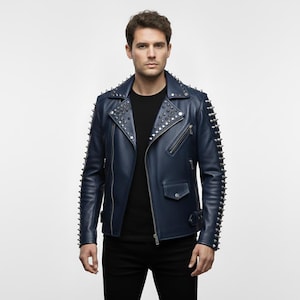 Könnte beinhalten: Dunkelblaue Lederjacke mit silbernen Metallnieten an Schultern und Ärmeln. Die Jacke hat einen klassischen Biker-Stil mit Reverskragen, asymmetrischem Reißverschluss und mehreren Taschen. Die Person trägt ein schwarzes Oberteil und eine schwarze Hose.