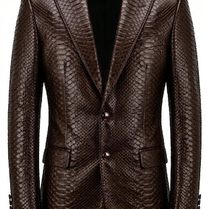 Peut inclure: Un blazer en cuir marron avec un motif peau de serpent. Le blazer a un revers cranté, deux poches avant et des boutons. Les manches ont des boutons aux poignets. La veste est de couleur marron moyen.