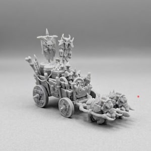 May include: A gray resin miniature of a fantasy supply wagon pulled by two tusked beasts. The wagon features wooden wheels with spikes, barrels, crates, and a tall banner displaying a skull and crossbones. A horned skull totem stands upright.