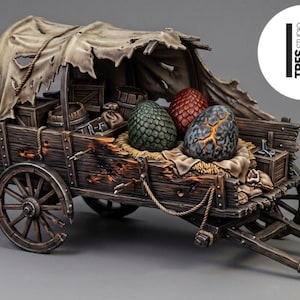 Puede incluir: Un carro de madera en miniatura con una cubierta de tela desgastada y rasgada, que transporta tres huevos texturizados con patrón de escamas en verde, rojo y gris con grietas naranjas. El carro incluye ruedas de madera, cajas y barriles.