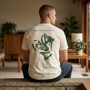 May include: A white ceramic mug with a black handle and the text "But First, Coffee" in a bold, black font. The mug is filled with a dark liquid, likely coffee, and sits on a light-colored surface.