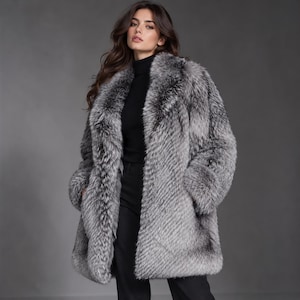 May include: A long-sleeved, mid-length faux fur coat featuring a variegated gray and white color palette with a thick, plush texture, a wide lapel collar, and a straight-cut hem, worn over a black turtleneck sweater and black trousers.