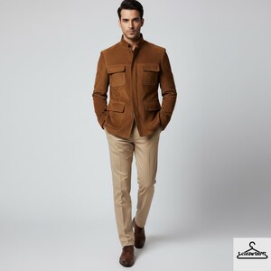 May include: A brown suede jacket with four front pockets and a mandarin collar. The jacket is paired with khaki pants and brown leather shoes. The model is walking towards the camera.