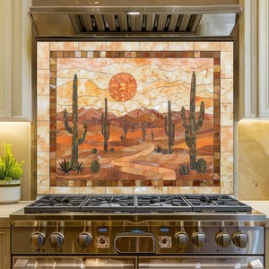 May include: A stainless steel double oven range with a decorative backsplash featuring a desert landscape with cacti, mountains, and a sun. The kitchen has light-colored cabinets and countertops, with plants and jars on the counter.