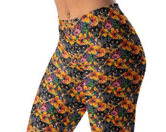May include: Leggings featuring a repeating pattern of black and tan chihuahua dog faces interspersed with vibrant orange, yellow, and pink hibiscus flowers against a dark green and grey background with subtle leaf motifs throughout the fabric.