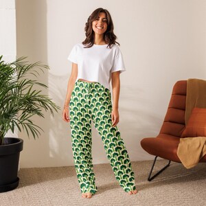 May include: Green and white pajama trousers with a repeating broccoli pattern. The trousers have a drawstring waist and a relaxed fit. The model is wearing a white crop top.