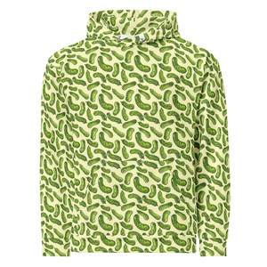 May include: A light yellow hoodie featuring a repeating pattern of green pickles. The hoodie has a high collar and a front pocket. The pickle design is detailed with shading, giving the impression of a hand-drawn illustration. The overall design is playful and eye-catching.