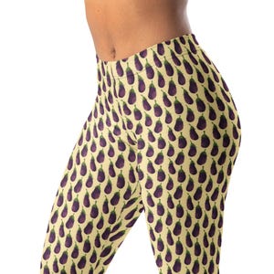 May include: Full-length leggings featuring a repeating pattern of small purple eggplants with green stems on a light cream-colored background. The leggings have a high-waisted design and a fitted silhouette that covers the legs from waist to ankle.