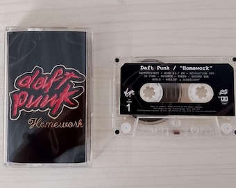May include: A clear cassette tape and case featuring the album "Homework" by Daft Punk. The cassette case has a black background with the band's logo in red and the album title in gold. The cassette tape displays the album title and tracklist.