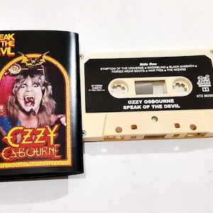 May include: A vintage cassette tape and its cover featuring Ozzy Osbourne's "Speak of the Devil" album. The cover is black with a portrait of Osbourne. The cassette is off-white with black text. The album title and song titles are visible.