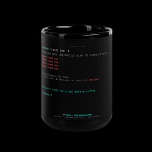 Può includere: Una tazza in ceramica nera con una stampa di interfaccia a riga di comando. Il testo mostra un comando ping a dad con errori di timeout in rosso, seguito dal messaggio: Dad doesn't reply to pings before coffee. Il testo alla base recita IT Dad - The Dadacenter.
