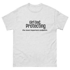 May include: A light gray t-shirt with the text "Girl Dad: Protecting the most important endpoint" in black. The shirt has a crew neck and short sleeves.