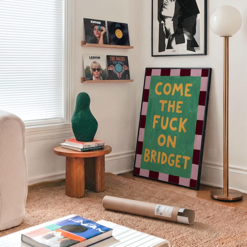 Come The Fuck On Bridget humorous wall art gift presentation in modern bedroom setting with music records and copper lamp, retro poster lifestyle display showing green and pink checkered design
