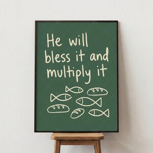 Peut inclure: Impression encadrée avec l'inscription "He will bless it and multiply it" en écriture blanche sur fond vert foncé. L'image comprend des dessins au trait de poissons et de pains.