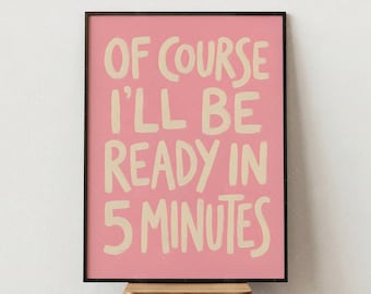 May include: A framed art print with a pink background and the text "OF COURSE I'LL BE READY IN 5 MINUTES" in a playful, handwritten style. The print is in a black frame and sits on a small wooden stool.