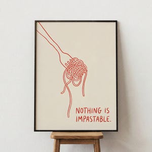 May include: A framed art print featuring a red line drawing of a fork twirling spaghetti. The text "NOTHING IS IMPASTABLE" is below the pasta. The artwork is on a cream-colored background.