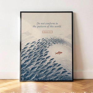 Puede incluir: Una lámina enmarcada sobre fondo beige claro que muestra un gran banco de peces azul oscuro nadando en forma de ola. Un solo pez rojo nada en dirección opuesta. El texto dice: Do not conform to the pattern of this world. Romans 12:2.