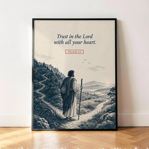 Può includere: Una stampa artistica da parete incorniciata che presenta un'illustrazione paesaggistica monocromatica di una persona in tunica che tiene un bastone, in piedi su un sentiero. Il testo recita: Trust in the Lord with all your heart. Proverbs 3:5.