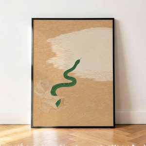 May include: A framed vertical art print featuring a green snake emerging from a textured, light-coloured organic shape. The background consists of a tan surface with fine, wavy line patterns and a large, smooth, off-white cloud-like area.