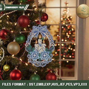 Pode incluir: Um enfeite de árvore de Natal com um design bordado em azul e branco de velas e flores. O enfeite está pendurado em uma árvore de Natal decorada com enfeites vermelhos, verdes e dourados. O texto "EMBROIDERY FILES" é visível.