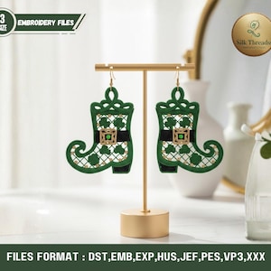 May include: A pair of green and black St. Patrick's Day boot earrings with gold-colored hooks. The earrings are displayed on a gold stand. The earrings have a clover design and are labeled as embroidery files. The image also includes the text "Silk Threadss".