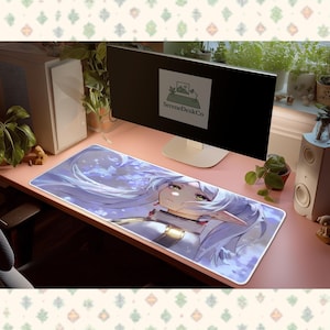 Może przedstawiać: Prostokątna podkładka pod biurko z ilustracją w stylu anime postaci z długimi białymi włosami, zielonymi oczami i białym i złotym strojem. Podkładka ma białą obwódkę i jest na różowym biurku. Tekst "SereneDeskCo" znajduje się na monitorze.