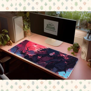 Puede incluir: Alfombrilla de ratón rectangular larga con un personaje de anime. La imagen muestra un personaje con cabello negro, ojos rojos y un atuendo rojo y negro. El fondo muestra un cielo rojo y árboles oscuros. La alfombrilla tiene el texto "SereneDeskCo".