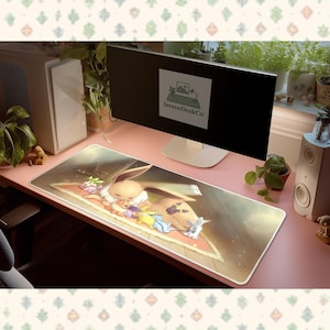 May include: A rectangular desk mat featuring a cartoon illustration of a sleeping Eevee character surrounded by other characters. The mat is primarily beige and brown with colorful accents. The text "SereneDeskCo" is visible on the computer screen.