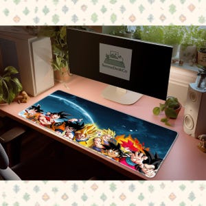 May include: A long rectangular mousepad featuring a vibrant illustration of anime characters in various action poses. The design includes characters with spiky hair, dynamic energy effects, and a blue and orange color scheme. The mousepad is on a pink desk.