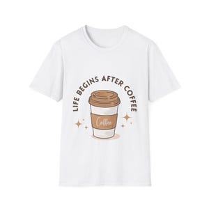 Può includere: T-shirt bianco con un'illustrazione di tazza di caffè e la scritta "LIFE BEGINS AFTER COFFEE". Il design presenta una tazza di caffè marrone con un manicotto di carta bianco e un coperchio marrone, con stelle.