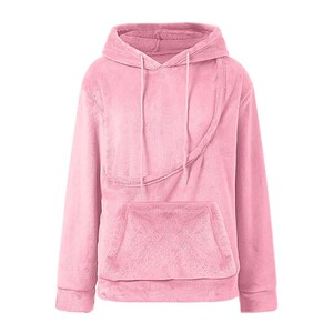 May include: A light pink, plush hoodie with a kangaroo pocket and a drawstring hood. The long-sleeved sweatshirt has a diagonal seam across the chest and a soft, fuzzy texture. The casual top is designed for comfort and warmth.