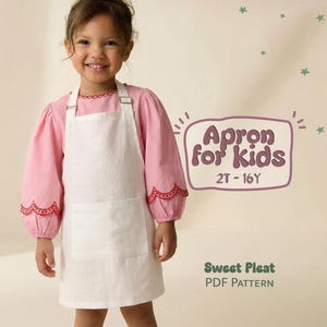 May include: A young child wearing a white apron over a pink long-sleeved shirt. The apron has a large front pocket and is secured with a metal buckle. The text "Apron for Kids" and "2T-16Y" is visible. The words "Sweet Pleat PDF Pattern" are also visible.