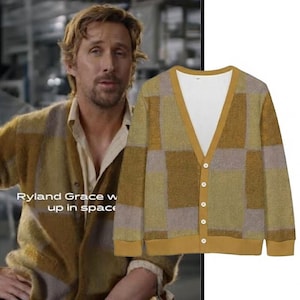 May include: A button-down cardigan sweater with a geometric pattern in shades of gold, tan, and gray. The sweater has a V-neck and a solid gold trim. The text "Ryland Grace w up in space" is visible.