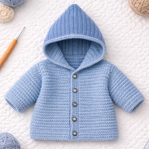 May include: A baby's light blue hooded jacket. The crochet jacket features long sleeves and a button-up front with five buttons. The hood is attached to the jacket. The jacket is made of a soft, textured yarn. The jacket is a handmade item.