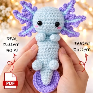 Peut inclure: Un jouet en peluche axolotl crocheté bleu clair et violet avec des yeux noirs et des joues roses. L'image contient le texte REAL Pattern NO AI et Tested Pattern, ainsi qu'une icône PDF, indiquant un document de modèle de crochet numérique.