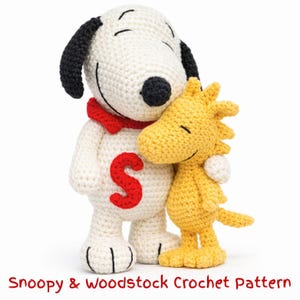 May include: Crocheted Snoopy and Woodstock figures. Snoopy is white with black ears and a red collar, and Woodstock is yellow. Snoopy has a red "S" on his chest. The text "Snoopy & Woodstock Crochet Pattern" is at the bottom.
