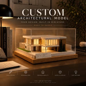 Może przedstawiać: Niestandardowy model architektoniczny nowoczesnego domu z podświetlanymi oknami, zamknięty w przezroczystej akrylowej gablocie na drewnianej podstawie. Model posiada białą konstrukcję, akcenty w kolorze drewna oraz miniaturowe drzewka.