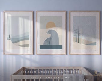 May include: A set of three vertical art prints in light wood frames. The left print shows a penguin in a landscape. The center print features two polar bears under a sun. The right print depicts a forest of thin trees against a muted sky.