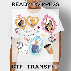May include: A white t-shirt featuring a DTF transfer with the text READY TO PRESS and DTF TRANSFER. The graphic includes cartoon characters in gold and pink frames, a pug, a coffee cup, a heart-shaped cake, and the text LISTEN WITH YOUR HEART.