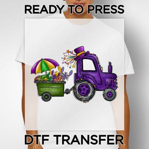 May include: A white t-shirt featuring a DTF transfer design. The design includes a purple tractor pulling a green trailer with an umbrella, and a top hat. The text "READY TO PRESS" and "DTF TRANSFER" are displayed.