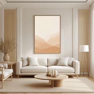 Puede incluir: Un salón moderno con una paleta de colores neutros. Una gran obra de arte abstracta enmarcada con tonos beige y marrón cuelga sobre un sofá blanco. Una mesa de centro de madera y una lámpara de pie completan el espacio.