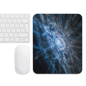 May include: A white wireless keyboard, a white mouse, and a rectangular mousepad. The mousepad features a blue and white abstract design resembling a cosmic explosion. The keyboard has a standard layout.