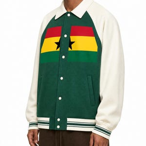 Op de afbeelding: Een donkergroen varsity-jack met crèmekleurige mouwen en een bijpassende kraag. De voorkant heeft een gespleten afbeelding van de vlag van Ghana met rode, gele en groene horizontale strepen en een zwarte ster. Het heeft een drukknoopsluiting en boorden.
